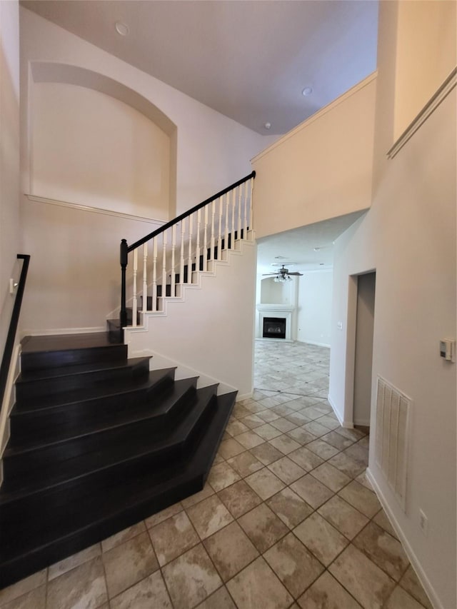 19734 Logan Briar Dr, Tomball, TX 77375 - staircase with a high ceiling, a ceiling fan, and baseboards