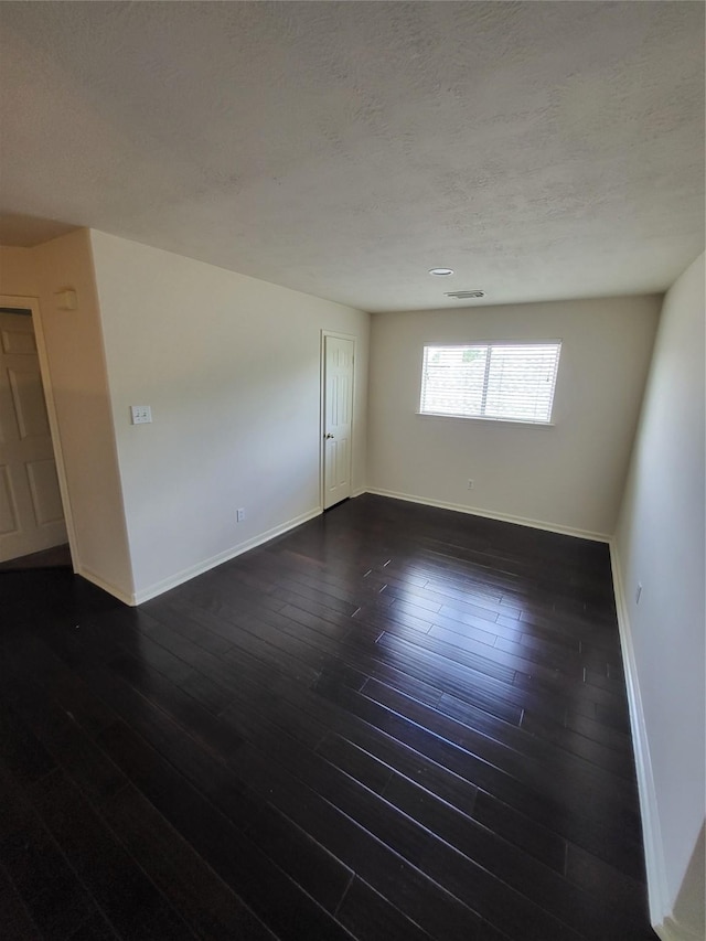 19734 Logan Briar Dr, Tomball, TX 77375 - spare room featuring baseboards, a textured ceiling, and dark wood-style flooring