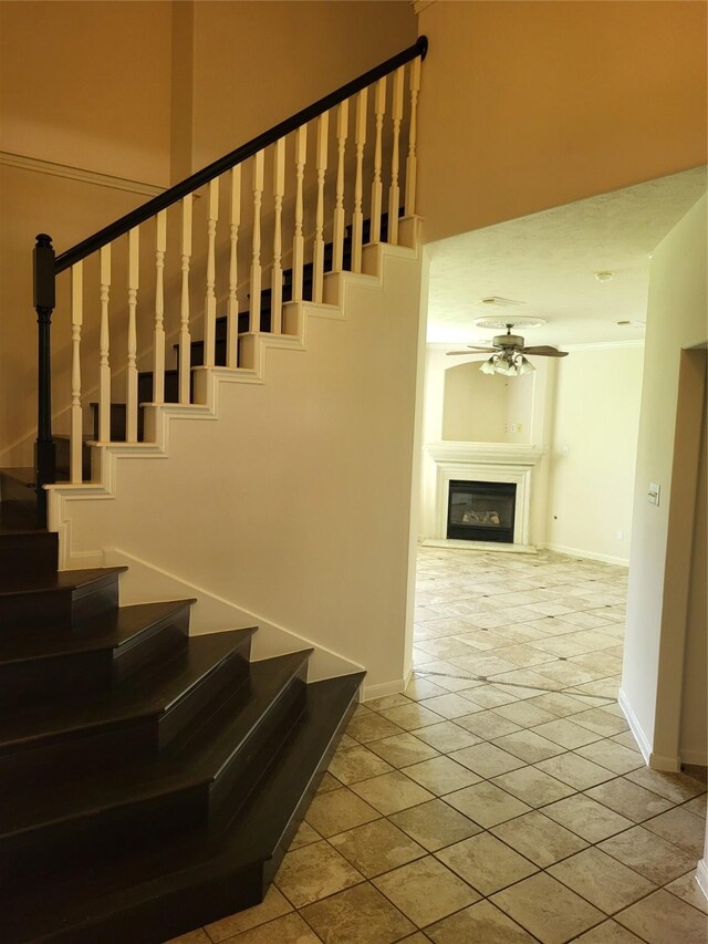 19734 Logan Briar Dr, Tomball, TX 77375 - stairway featuring baseboards, a glass covered fireplace, and ceiling fan