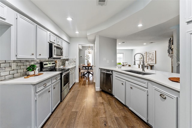 14116 Misty Meadow Ln, Houston, TX 77079 - kitchen featuring a sink, appliances with stainless steel finishes, tasteful backsplash, recessed lighting, and light countertops