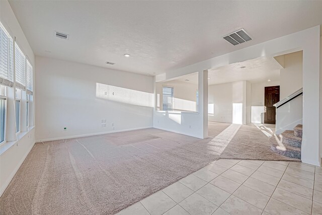 7106 Escondido Dr, Rosharon, TX 77583 - spare room with light colored carpet, light tile patterned floors, healthy amount of natural light, stairs, and recessed lighting