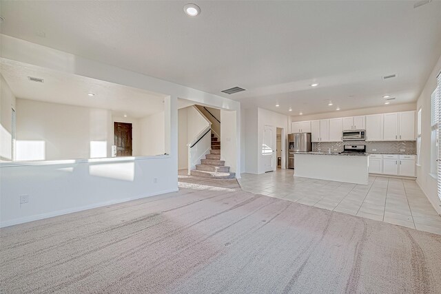7106 Escondido Dr, Rosharon, TX 77583 - unfurnished living room featuring stairs, light colored carpet, recessed lighting, light tile patterned floors, and baseboards
