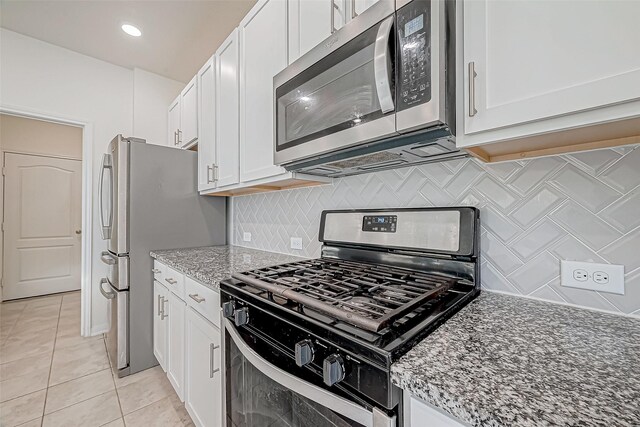 7106 Escondido Dr, Rosharon, TX 77583 - kitchen with appliances with stainless steel finishes, white cabinetry, light tile patterned flooring, light stone counters, and backsplash