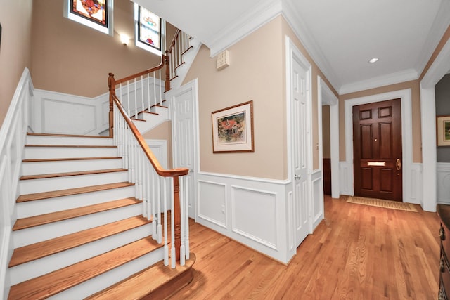 3820 Purdue St, Houston, TX 77005 - foyer entrance with crown molding, a decorative wall, stairway, light wood-type flooring, and wainscoting
