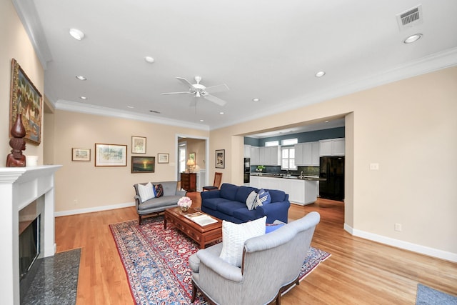 3820 Purdue St, Houston, TX 77005 - living area with ceiling fan, crown molding, light wood finished floors, baseboards, and a fireplace with flush hearth