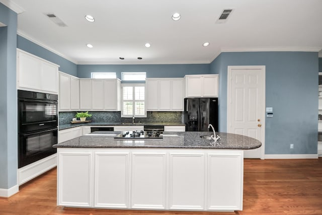 3820 Purdue St, Houston, TX 77005 - kitchen featuring black appliances, a sink, ornamental molding, an island with sink, and white cabinets