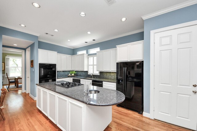 3820 Purdue St, Houston, TX 77005 - kitchen featuring black appliances, a kitchen island with sink, decorative backsplash, recessed lighting, and white cabinetry
