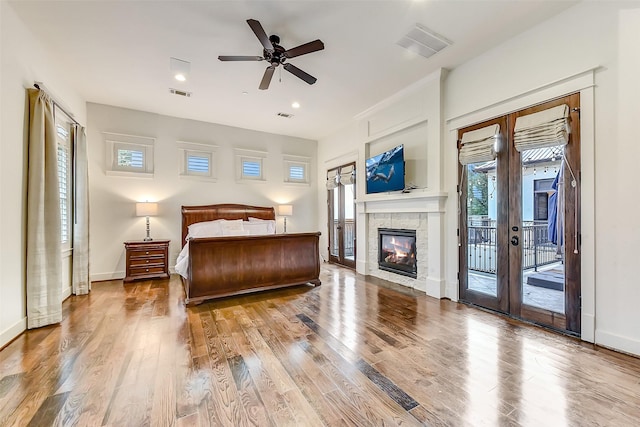 8305 Will Jordan Pkwy, Bellaire, TX 77401 - bedroom featuring access to outside, wood finished floors, a tiled fireplace, baseboards, and recessed lighting