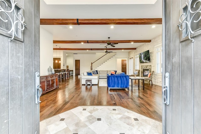 8305 Will Jordan Pkwy, Bellaire, TX 77401 - entrance foyer with stairway, beam ceiling, wood finished floors, a stone fireplace, and ceiling fan