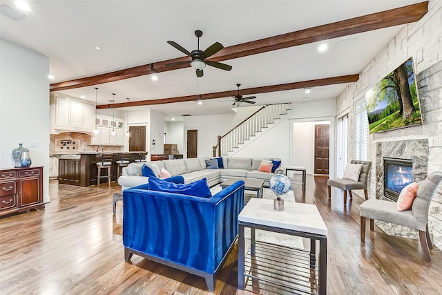 8305 Will Jordan Pkwy, Bellaire, TX 77401 - living area with light wood-style floors, ceiling fan, beamed ceiling, stairway, and a fireplace