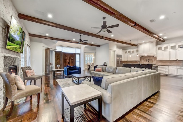 8305 Will Jordan Pkwy, Bellaire, TX 77401 - living room with ceiling fan, beam ceiling, dark wood-style flooring, healthy amount of natural light, and a fireplace
