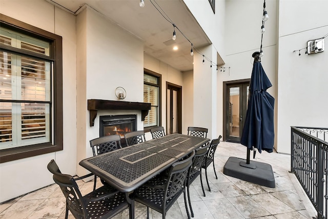 8305 Will Jordan Pkwy, Bellaire, TX 77401 - view of patio / terrace featuring outdoor dining space and a warm lit fireplace