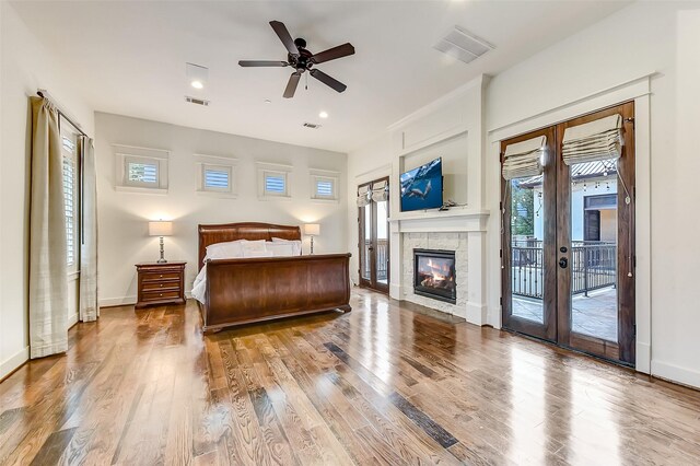 8305 Will Jordan Pkwy, Bellaire, TX 77401 - bedroom featuring access to outside, wood finished floors, a stone fireplace, baseboards, and recessed lighting