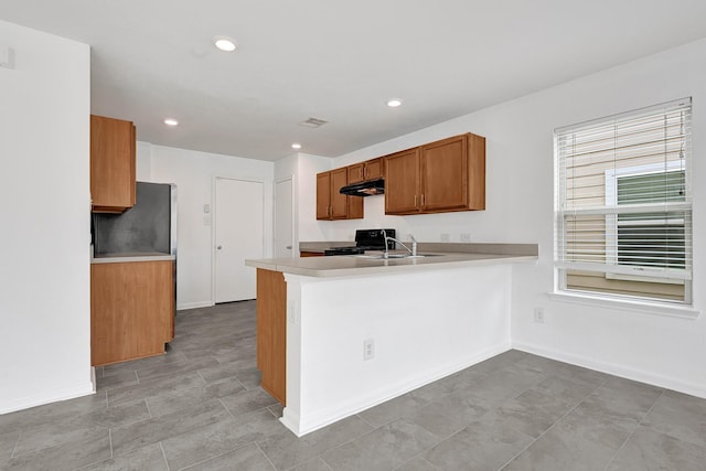 19311 Old Finch Ct, Houston, TX 77073 - kitchen featuring gas stove, refrigerator, brown cabinetry, under cabinet range hood, and light countertops