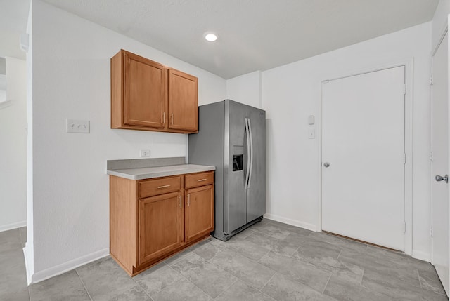 19311 Old Finch Ct, Houston, TX 77073 - kitchen featuring stainless steel fridge, light countertops, baseboards, and brown cabinetry