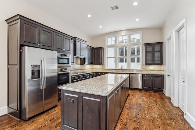 3917 Gramercy St, Houston, TX 77025 - kitchen with appliances with stainless steel finishes, dark brown cabinets, a center island, recessed lighting, and lofted ceiling
