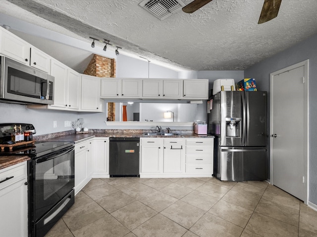 9731 Rocky Hollow Rd, La Porte, TX 77571 - kitchen featuring stainless steel appliances, lofted ceiling, dark countertops, light tile patterned flooring, and a textured ceiling