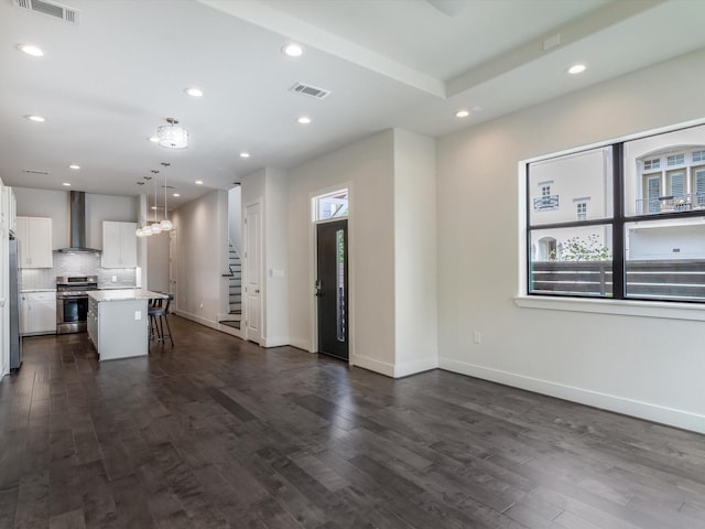 2301 Arabelle St, Houston, TX 77007 - kitchen with appliances with stainless steel finishes, wall chimney range hood, a breakfast bar, white cabinetry, and light countertops