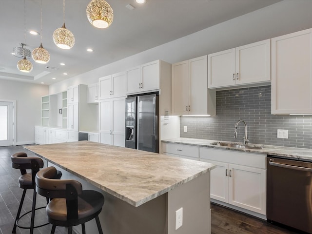 2301 Arabelle St, Houston, TX 77007 - kitchen featuring stainless steel appliances, a sink, backsplash, dark wood-style floors, and white cabinetry