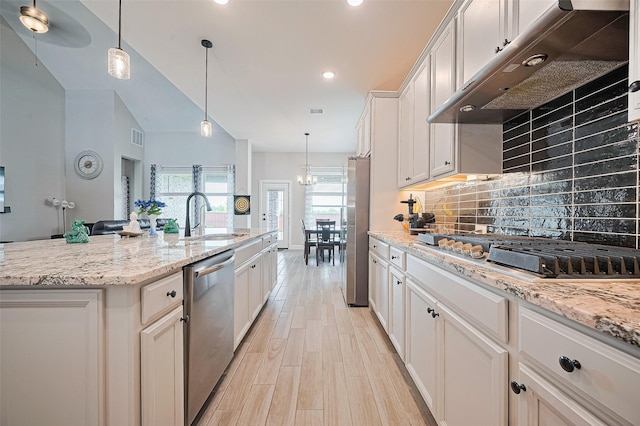 13811 Via Toluca Trl, Cypress, TX 77433 - kitchen with stainless steel appliances, a sink, decorative backsplash, ventilation hood, and light wood-type flooring