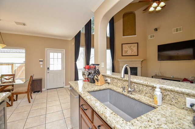 13023 Forester Canyon Ln, Sugar Land, TX 77498 - kitchen with a sink, dishwasher, light tile patterned floors, light stone countertops, and crown molding