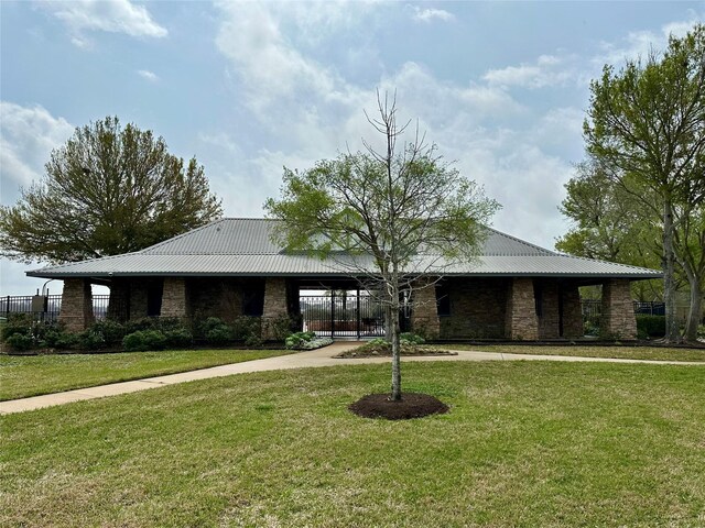 13023 Forester Canyon Ln, Sugar Land, TX 77498 - view of front of house featuring stone siding, a front yard, metal roof, and curved driveway