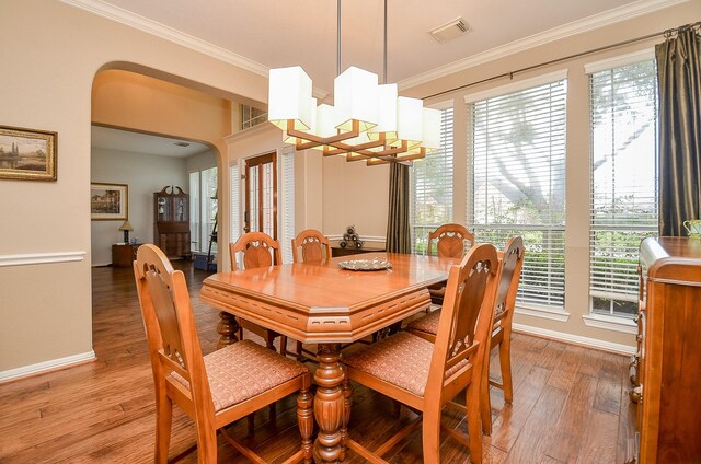 13023 Forester Canyon Ln, Sugar Land, TX 77498 - dining space featuring light wood-style floors, ornamental molding, arched walkways, and baseboards