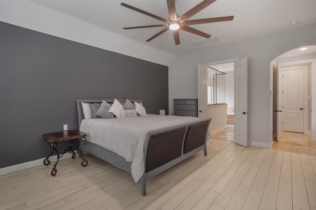 700 Southfield Dr, Friendswood, TX 77546 - bedroom featuring arched walkways, light wood-style flooring, a ceiling fan, and ensuite bathroom