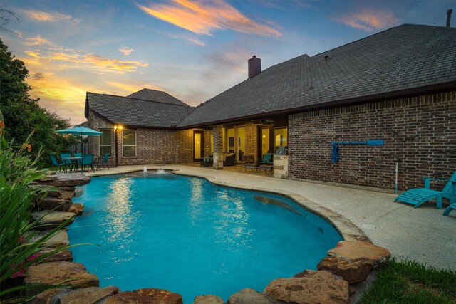 700 Southfield Dr, Friendswood, TX 77546 - pool at dusk with a patio area, an outdoor pool, and outdoor dining space