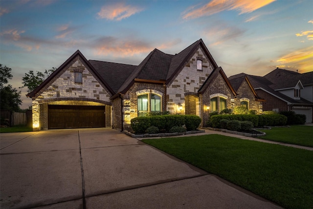 700 Southfield Dr, Friendswood, TX 77546 - french country home with concrete driveway, stone siding, and a yard