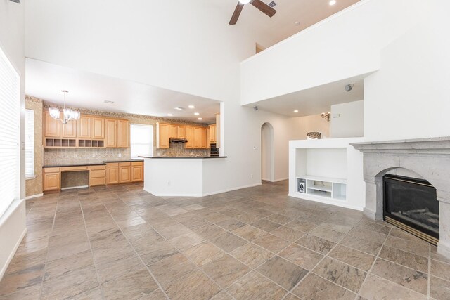 5923 Union Spgs, Sugar Land, TX 77479 - unfurnished living room with built in shelves, a ceiling fan, arched walkways, a high end fireplace, and baseboards