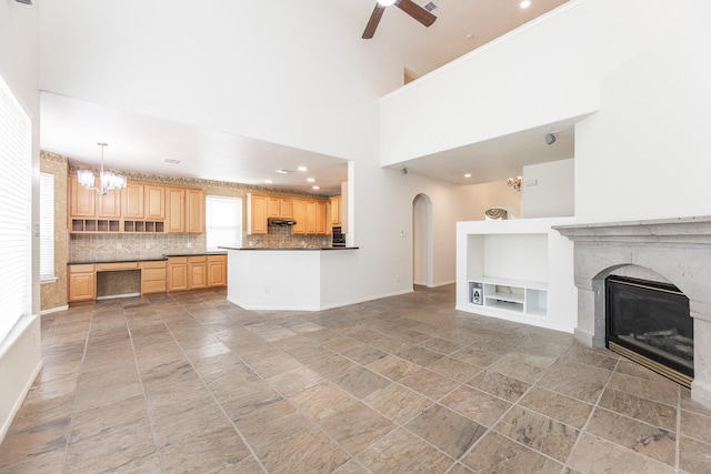 5923 Union Spgs, Sugar Land, TX 77479 - unfurnished living room featuring built in features, a ceiling fan, arched walkways, baseboards, and a premium fireplace