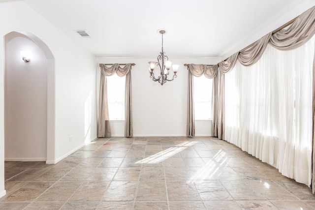 5923 Union Spgs, Sugar Land, TX 77479 - empty room with stone tile flooring, arched walkways, a chandelier, and baseboards