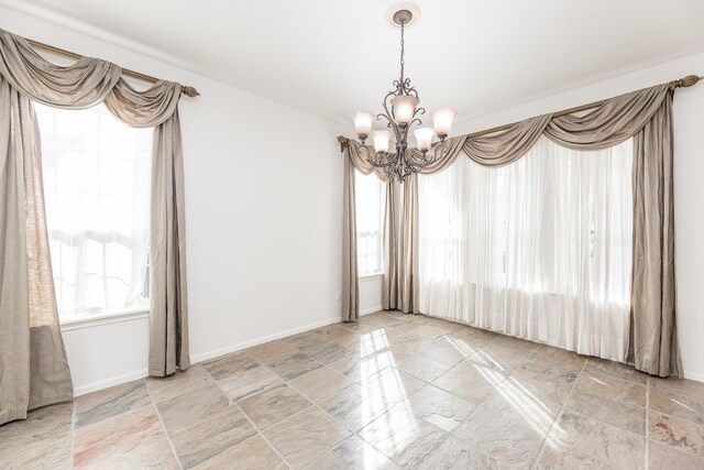 5923 Union Spgs, Sugar Land, TX 77479 - empty room featuring a chandelier, stone tile floors, and baseboards