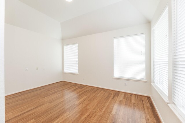 5923 Union Spgs, Sugar Land, TX 77479 - spare room featuring light wood-style floors, baseboards, and vaulted ceiling