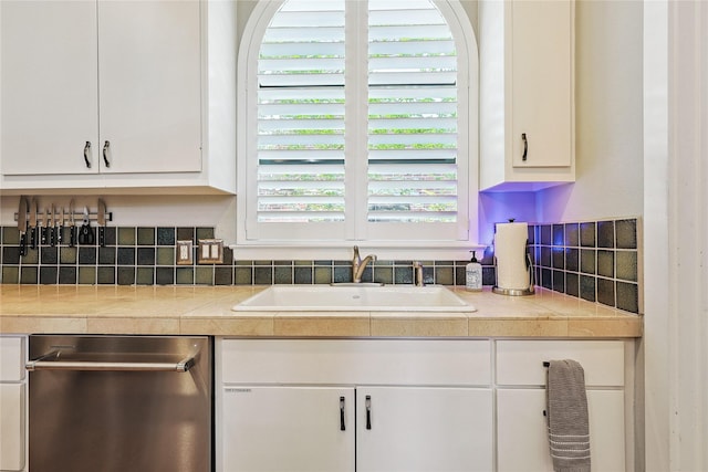 2505 Brinkman St, Houston, TX 77008 - kitchen with stainless steel dishwasher, a sink, white cabinetry, and backsplash