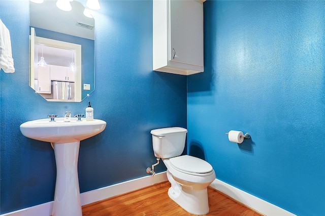 2505 Brinkman St, Houston, TX 77008 - bathroom featuring toilet, baseboards, and wood finished floors