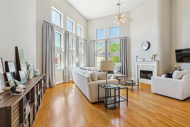 2505 Brinkman St, Houston, TX 77008 - living room featuring a high ceiling, a ceiling fan, light wood finished floors, a tile fireplace, and baseboards