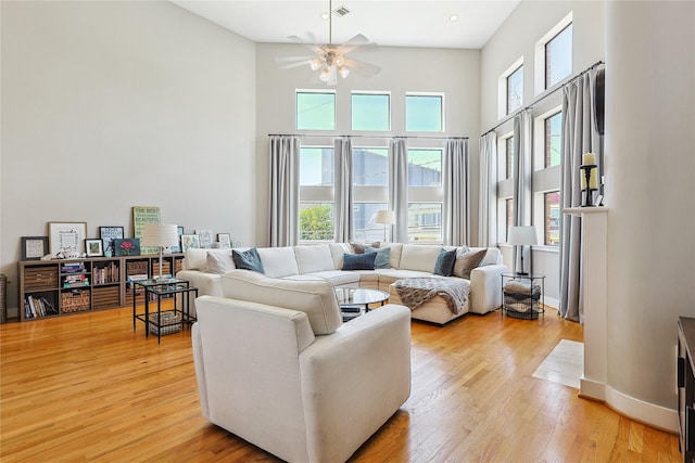 2505 Brinkman St, Houston, TX 77008 - living area with a ceiling fan, a towering ceiling, light wood-style floors, and baseboards