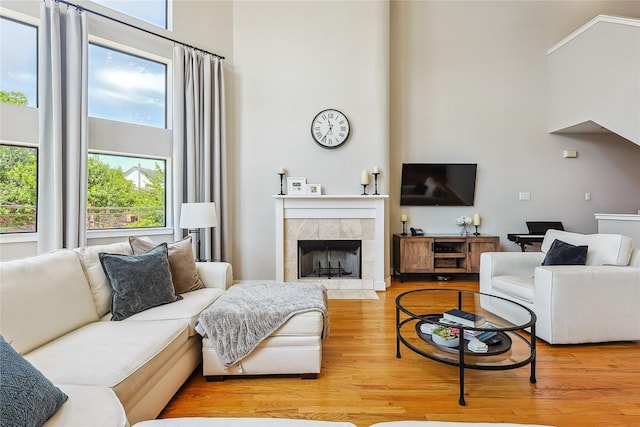 2505 Brinkman St, Houston, TX 77008 - living room featuring a high ceiling, plenty of natural light, wood finished floors, and a tile fireplace