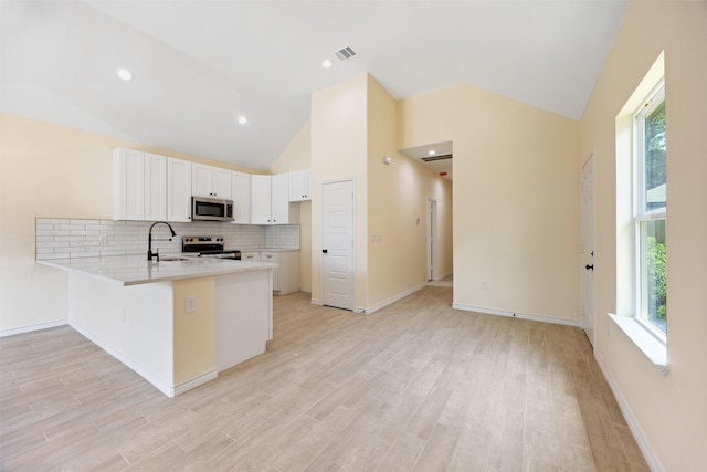 16960 W Dounreay, Montgomery, TX 77316 - kitchen with appliances with stainless steel finishes, a peninsula, vaulted ceiling, light countertops, and tasteful backsplash