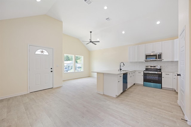 16960 W Dounreay, Montgomery, TX 77316 - kitchen with appliances with stainless steel finishes, a peninsula, a ceiling fan, tasteful backsplash, and open floor plan