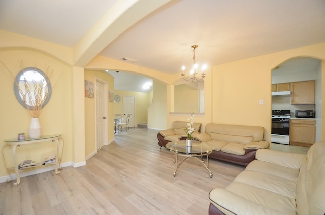 7102 Biton Dr, Houston, TX 77083 - living room with arched walkways, light wood-style flooring, a chandelier, and baseboards