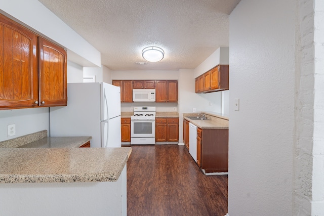 2302 Peaceful Valley Dr, Spring, TX 77373 - kitchen featuring white appliances, a sink, a textured ceiling, dark wood finished floors, and brown cabinetry