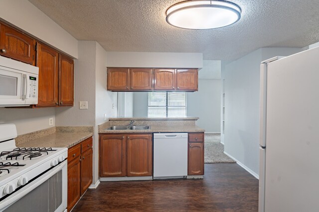 2302 Peaceful Valley Dr, Spring, TX 77373 - kitchen with white appliances, a sink, a textured ceiling, dark wood-style floors, and brown cabinets