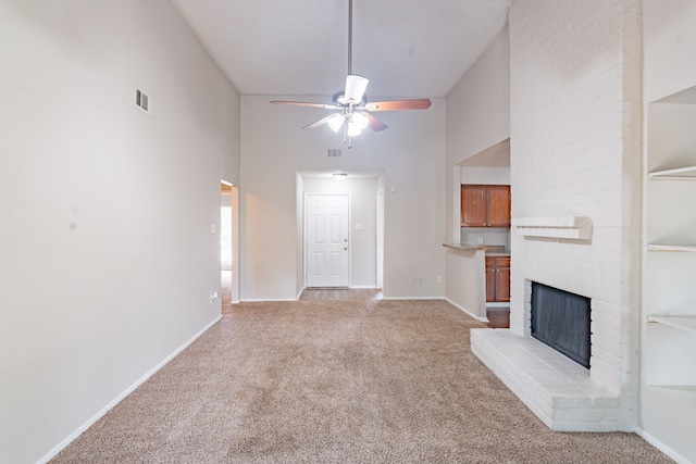 2302 Peaceful Valley Dr, Spring, TX 77373 - unfurnished living room with light colored carpet, a ceiling fan, a brick fireplace, baseboards, and a towering ceiling