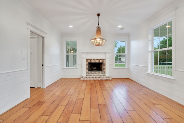 5926 Bit Pl, Baytown, TX 77523 - unfurnished living room featuring ornamental molding, light wood-style floors, a chandelier, wainscoting, and a fireplace