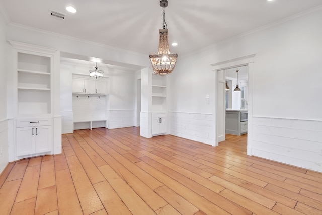 5926 Bit Pl, Baytown, TX 77523 - unfurnished dining area featuring a chandelier, wainscoting, crown molding, light wood-type flooring, and built in features