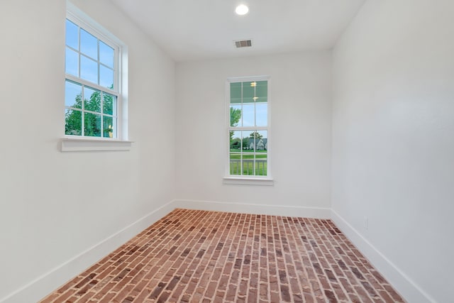 5926 Bit Pl, Baytown, TX 77523 - spare room featuring plenty of natural light, baseboards, brick patterned floors, and recessed lighting