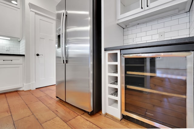 5926 Bit Pl, Baytown, TX 77523 - kitchen featuring stainless steel fridge with ice dispenser, dark countertops, beverage cooler, backsplash, and white cabinetry